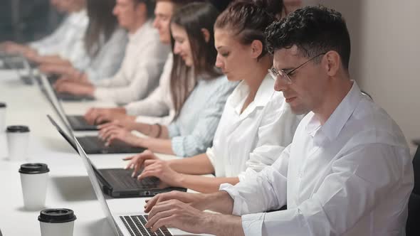 Employees with Office Manager Working on a Laptop