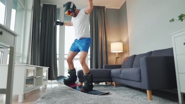 Fun Video. Man in Shorts, T-shirt and Snowboarding Equipment Happily Dancing and Having Fun on a