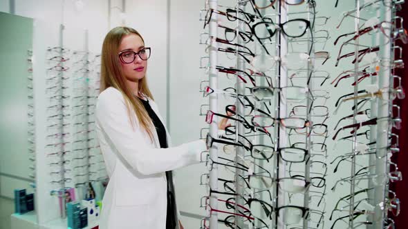 Young Woman Is Choosing a Glasses