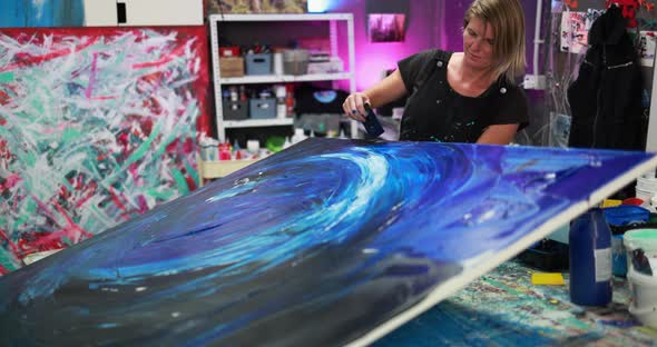 Mature woman painting inside her atelier studio