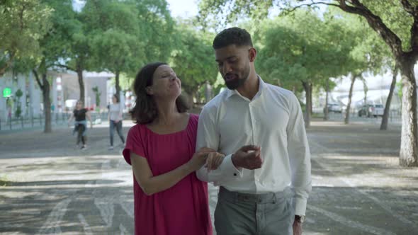 Smiling Couple Talking While Strolling in Summer Park.