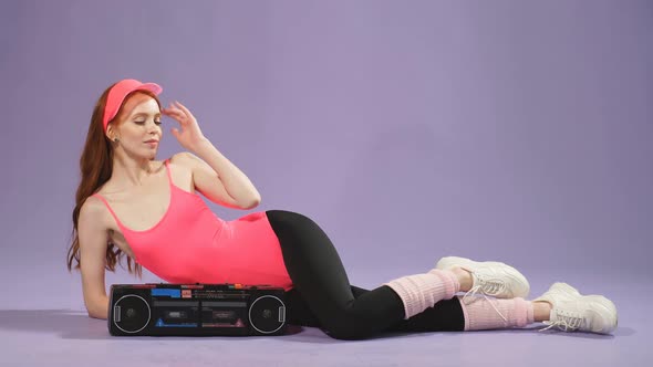 Cheerful Athletic Woman Sits After Fitness Training Turning Off Portable Audio Player