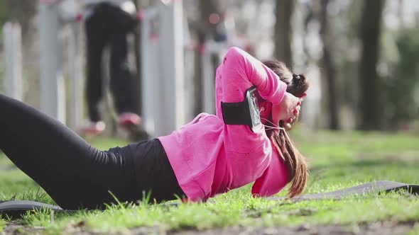 Young woman doing abs exercises at park