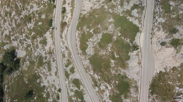 The Cyclist is Moving on a Narrow and Dangerous Mountain Road Located in Biokovo Park in Croatia