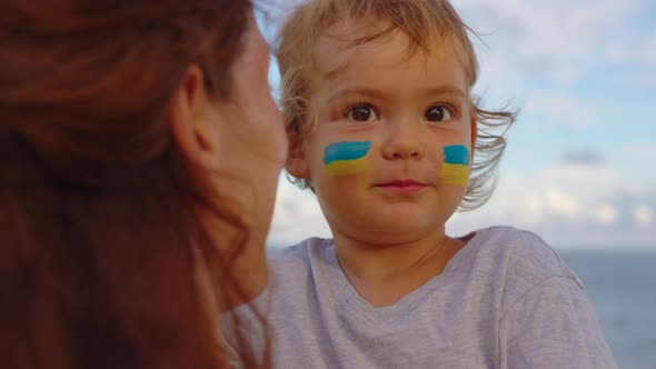 Close Up Portrait Little Baby and Mom with Flag of Ukraine on Face