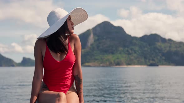 Woman In Swimsuit And Sunhat On Deck Of Boat