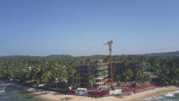 Crane on Construction Territory Between Forests and Ocean