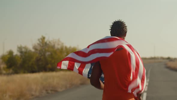 Black Confident Man Runs with an American Flag on Back