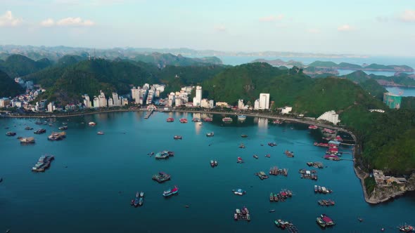 Aerial: sunset clear sky at Cat Ba island and city skyline between headlands Ha Long Bay Vietnam