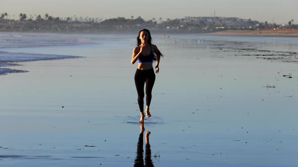 Slow motion shot of an Asian woman jogging on the beach