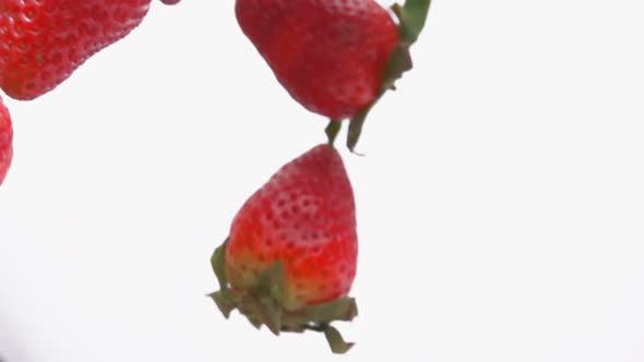 Closeup of the Fresh Red Strawberries Rotating on the White Background