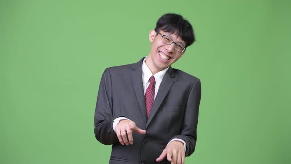 Young Happy Asian Businessman Laughing While Holding Stomach