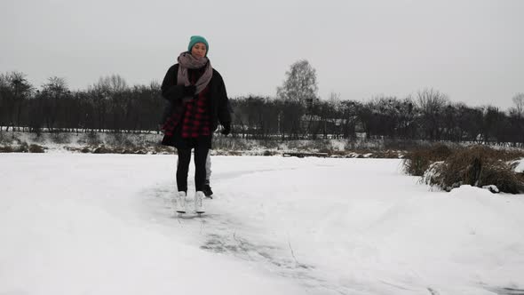 People are gliding on skates on frozen lake