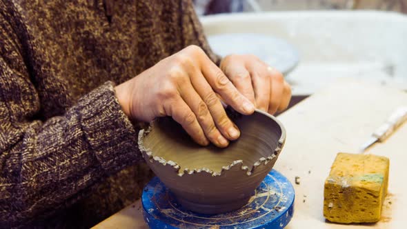 Potter carving on earthenware bowl