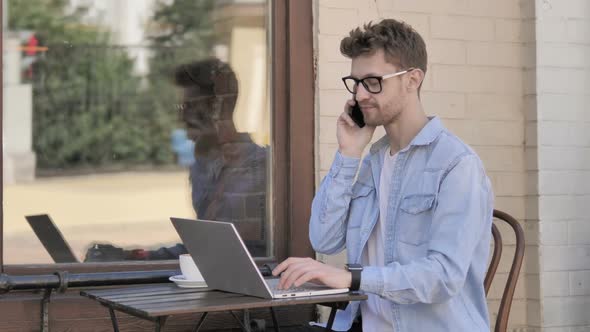 Man Talking on Phone While Sitting Outdoor