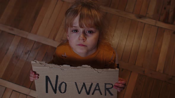 Scared Homeless Toddler Girl Sitting Holding Inscription No War Hiding From Bombing Attack at Home