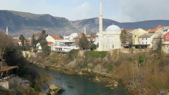 Full shot of the Koski Mehmed Pasha Mosque on the opposite bank of the Neretva River in Mostar