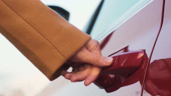 A Womans Hand Brings a Finger to the Car Door Handle Closes It and the Side Mirror Folding