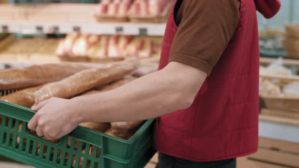 Male Supermarket Worker Displaying Fresh Bread