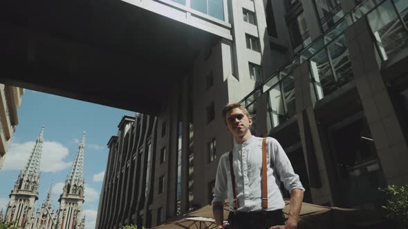 Man Looking to Camera While Standing Outdoors Business Building on the Background