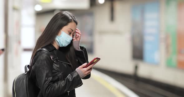 Chinese woman at train station in London wearing face mask