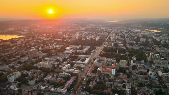 Aerial drone view of Chisinau downtown at sunset. Panorama view of multiple buildings, roads with mo