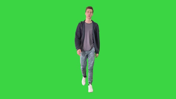 Young Attractive Student Walking Forward on a Green Screen, Chroma Key.