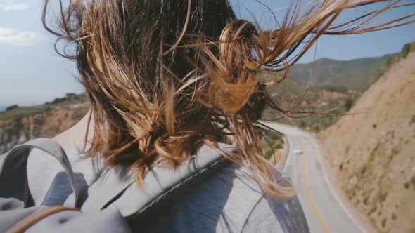 Close-up Back View Young Tourist Woman with Hair Flying in Strong Wind