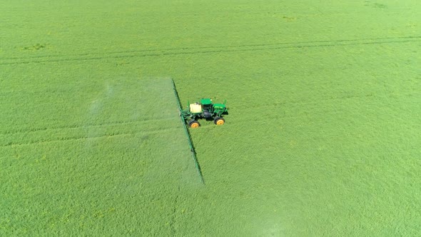 The Protection Of Plants.Tractor Spraying A Green Rapeseed Field