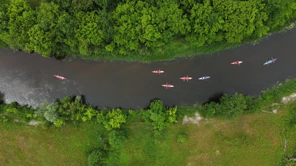 Aerial View of a Group of Kayaks Traveling on a Forest River on a Summer Day