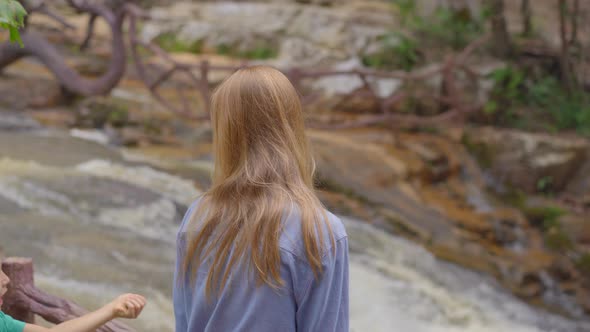 A Young Woman Visits Waterfall in Mountains. Travel To Dalat Concept