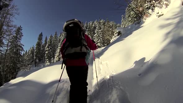 Two people cross-country skiing on a snow covered mountain.