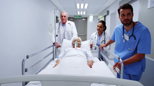 Doctors and nurse pushing emergency stretcher bed in corridor