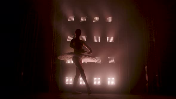Graceful Silhouette Ballerina Dancing in Black Dress in the Studio in Spotlight on the Stage of the