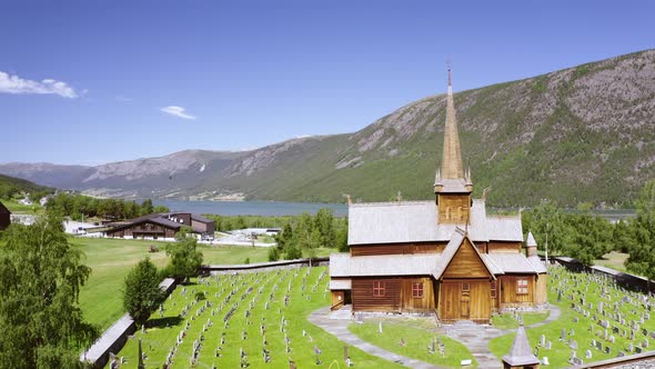 Stunning View Of Lom Stave Church (Lom Stavkyrkje) In Oppland, Norway. - Aerial Wide Shot