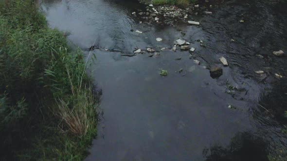 Streams of water flow through concrete pipes. Polluted body of water in the park.