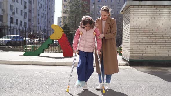 Mom Helps Daughter Learn to Walk on Crutches