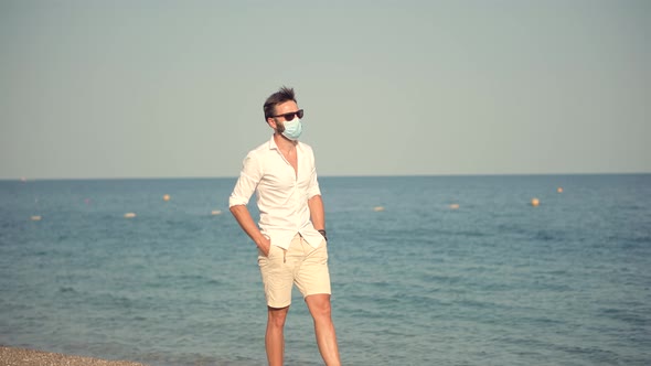 Sad Man In Face Mask At Covid Looking On Sea New Normal. Lockdown On Vacation. Covid-19