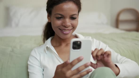 Positive African Woman talking by video call at phone