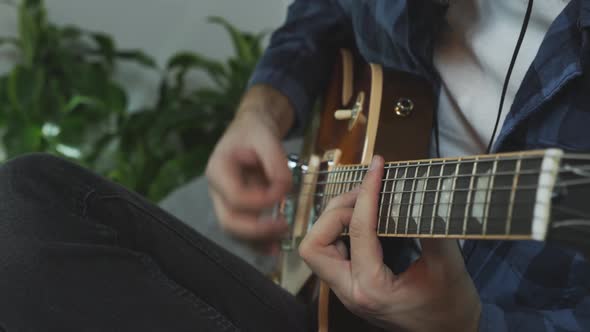 Man hands strumming and changing chords on electric guitar. Music concept