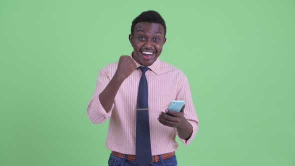 Happy Young African Businessman Using Phone and Getting Good News