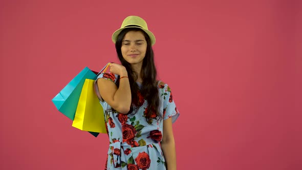 Shopaholic Girl with Bags in Her Hands Is Standing and Starts Smiling