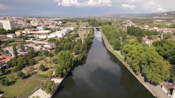 Cloudscape reflected on Tamega river, Chaves, Portugal. Aerial pullback