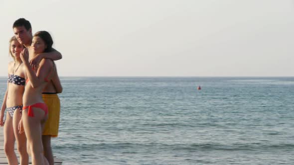 Three friends waving on jetty