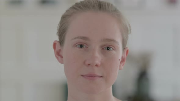 Close Up of Serious Beautiful Young Woman Looking at Camera