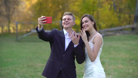 Newlyweds Take Selfie on Phone Against the Backdrop of Beautiful Autumn Landscape at Sunny Day.