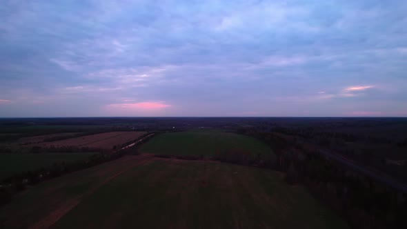 The Field Under the Dark Pink Sky in the Evening is Taken From a Drone