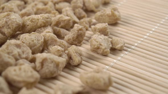 Textured soybean granules on a traditional bamboo mat close-up