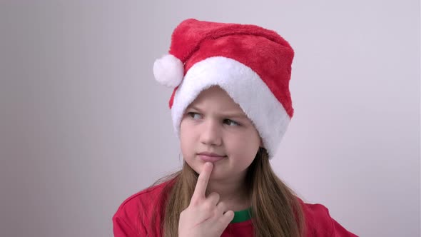 Portrait of Little Smart Girl in Christmas Red Hat on White Background