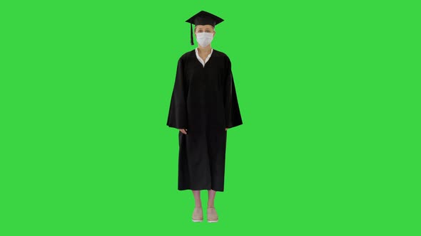 Female Graduate Student in a Medical Mask Standing on a Green Screen, Chroma Key